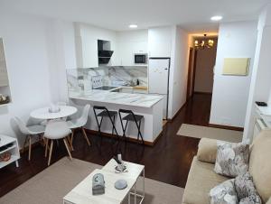 a living room with a couch and a kitchen at Cruz de Baixar in Fisterra