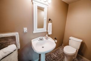 a bathroom with a white sink and a toilet at The Watermark Suite - Downtown in Drumheller