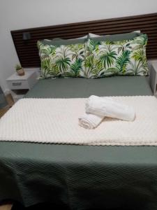 a bed with a towel on top of it at Vivenda Silva in Seixal