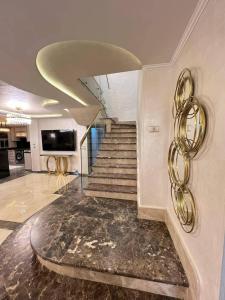 a lobby with a staircase with a gold spiral at الازرق فارم in Al Azraq ash Shamālī