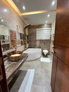 a bathroom with a tub and a sink and a toilet at الازرق فارم in Al Azraq ash Shamālī