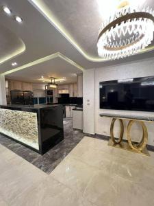 a large kitchen with a chandelier and a counter with two rings on it at الازرق فارم in Al Azraq ash Shamālī