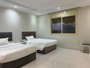 a bedroom with two beds and a window at رومانوس فيلاجيو ROMANOS Villagio in Obhor