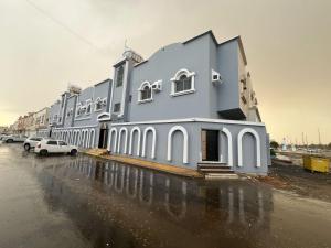a large building with cars parked in a parking lot at استوديو 104 in Tabuk