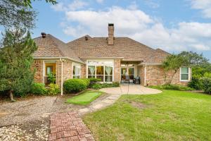 a home with a brick house with a grass yard at Spacious Family Retreat in Fort Worth Area! in Aledo