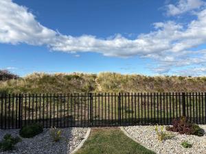 a black fence in front of a field at Beachfront Holiday Home Close to Airport in Lauderdale