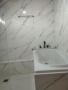 a white bathroom with a sink and marble walls at DON ESTEBAN - Departamento in Resistencia