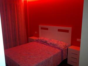 Habitación roja con 2 camas y pared roja. en Residencial Parque los Laureles, en Portonovo