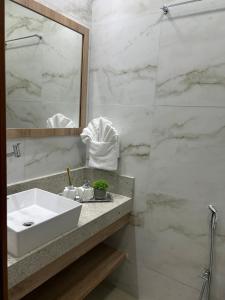 a bathroom with a sink and a mirror at Del Mar SG Apartment in Trairi +20 photos