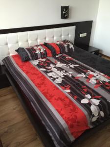 a bed with a black and red comforter at Apartment Beach View Plaza in Pomorie