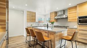 een keuken met houten kasten en een eiland met barkrukken bij Pacific Crest Hotel Santa Barbara in Santa Barbara