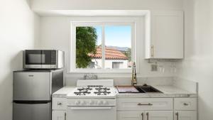 een witte keuken met een fornuis en een raam bij Pacific Crest Hotel Santa Barbara in Santa Barbara +9 foto's