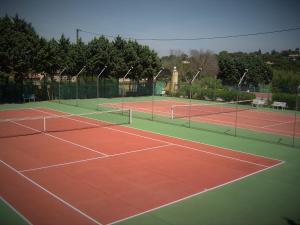 una pista de tenis con 2 pistas de tenis en Hotel La Romarine en Saint-Tropez