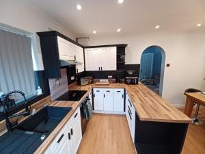 a kitchen with white cabinets and wooden counters at Glenmead in Birmingham
