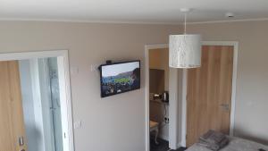 ein Wohnzimmer mit einem TV an der Wand in der Unterkunft Castaway Guesthouse in Kirkwall