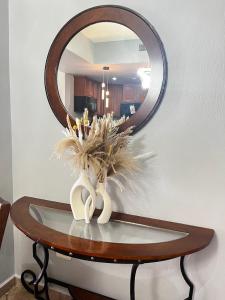 a vase of flowers on a table with a mirror at Las Palomas Beach & Golf Resort in Puerto Peñasco