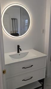 a bathroom with a white sink and a mirror at Le Narval Hébergement Touristique in Saint-Siméon +12 photos