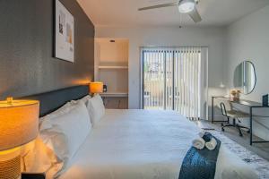 ein Schlafzimmer mit einem großen weißen Bett und einem Schreibtisch in der Unterkunft Deluxe 1BD King Bed Pool, Hot Tub, Gym, Parking in Glendale