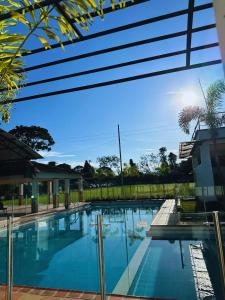 una piscina en una casa con un cielo azul en Cofradia Lodge, en Villavicencio