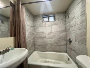 a bathroom with a white tub and a sink at Ponca Motel in Abilene