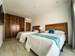 a bedroom with two beds with blue pillows at Beautiful Celeste Condominium in La Paz