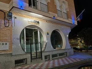 a building with two windows and a sign on it at Hostal Alhambra in Mocejón