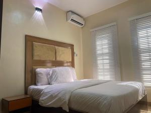 um quarto com uma cama com lençóis e travesseiros brancos em Kiscourt apartment em Meran