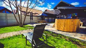 a chair sitting in the grass in front of a house at Alpine Homes in Zărneşti