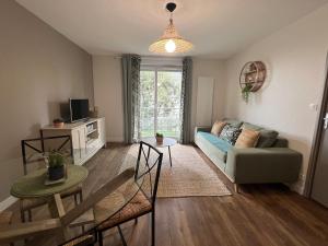 a living room with a couch and a table at Appartement Nature au calme in Albi