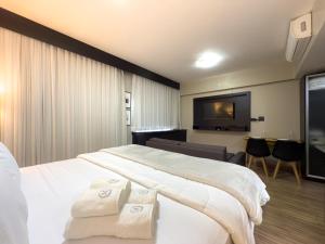 a bedroom with a large bed and a flat screen tv at Flat 702 Suite Patio Paulista - Bela Vista in Sao Paulo