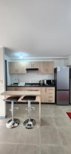 a kitchen with a table and a refrigerator at Dormitorio individual - Baño, Altos de San Miguel in Talca