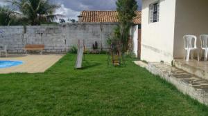 a yard with chairs and a fence and a house at Sítio Rodrigues in Pedro Leopoldo