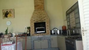 a kitchen with a stove and a brick oven at Sítio Rodrigues in Pedro Leopoldo