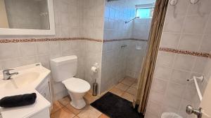 a bathroom with a toilet and a sink and a shower at Riverview Kalbarri 5 | Waterfront | Pool | Sleeps 5 in Kalbarri