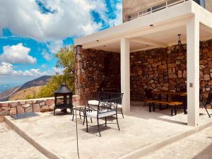 a patio with a table and chairs and a stone wall at El Callejón PLATA in Real de Catorce