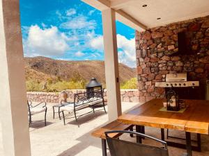 a patio with a table and chairs and a stone wall at El Callejón PLATA in Real de Catorce