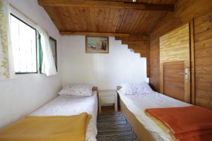 zwei Betten in einem Zimmer mit Holzdecken in der Unterkunft Secluded fisherman's cottage Cove Ducac, Brac - 24291 in Postira
