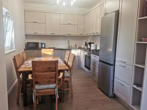 ザダルにあるHoliday house with a parking space Zadar - 24453のテーブルと椅子と冷蔵庫のあるキッチン