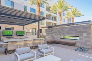 a patio with a bar and chairs and a building at Relaxing 1BD - Pool, Gym, Parking, W-D - Sleeps 4 in Tempe