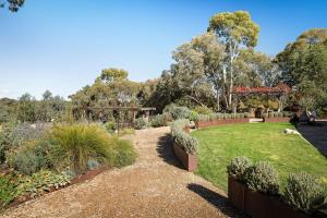 a garden with a path and bushes and trees at HeartStone Hill - Studio in Castlemaine