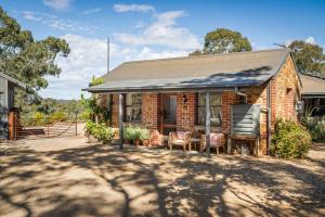 a brick house with a metal roof on a driveway at HeartStone Hill - Studio in Castlemaine