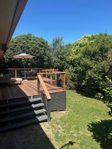 a deck with an umbrella and a table and chairs at Valley House - Location Location Location - Comfortable home in the heart of Healesville in Healesville