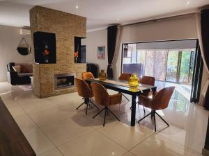 a dining room with a table and chairs and a fireplace at The Green leaf Executive Home in Pretoria
