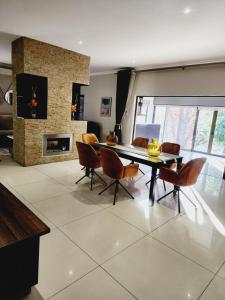 a living room with a table and chairs and a fireplace at The Green leaf Executive Home in Pretoria