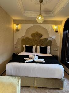 a bedroom with a large bed with two stuffed animals on it at Riad M'Barka in Tangier +28 photos