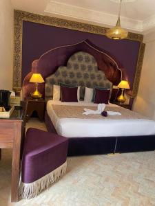 a bedroom with a large bed with a purple wall at Riad M'Barka in Tangier