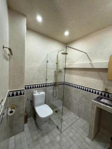 a bathroom with a toilet and a glass shower at Riad M'Barka in Tangier +29 photos