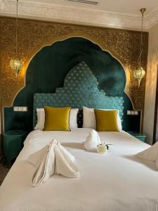 a bedroom with a large bed with a large headboard at Riad M'Barka in Tangier