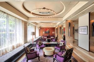 a hotel lobby with purple chairs and a large window at Hotel Indonesia Kempinski Jakarta in Jakarta