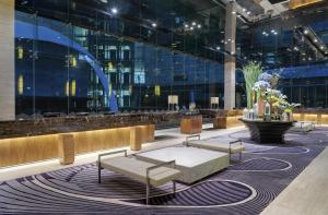 a lobby with benches and a table in a building at Hotel Indonesia Kempinski Jakarta in Jakarta